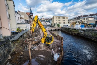 Hochwasserschutz im Erzgebirge: Was damit eine neugebaute Brücke in der Mulde zu tun hat - Bagger in der Mulde in Aues Innenstadt: Hier werden neue Mauern für den Hochwasserschutz gebaut.
