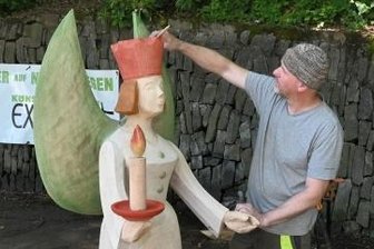Hölzerner Engel zieht Blicke auf sich - Friedhelm Schelter aus Königswalde frischt mit einem Pinsel die Farbe an seinem Engel auf.