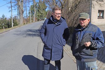 Hoffnung für die Holperpiste von Zug: Wann will Freiberg die Dorfstraße erneuern? - Hubert Göhler (r.) und Steve Ittershagen auf der Dorfstraße im Freiberger Stadtteil Zug.