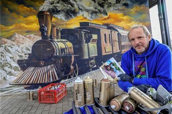 Hohenstein-Ernstthal: Restaurierte Westerneisenbahn dampft jetzt vor goldenem Abendhimmel - Die Spraydosen sind leer. Die Wand erstrahlt dafür in frischen Farben. Am Mittwoch hat Jens "Tasso" Müller aus Meerane die Restaurierung der Westerneisenbahn am Bahnhofsgebäude in Hohenstein-Ernstthal abgeschlossen.