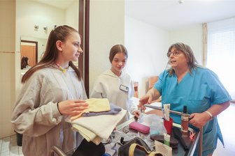 Hoher Stundenausfall in Chemnitz: Welche Lösungsmöglichkeiten gibt es schon? - Isabella Stein und Tamara Schumacher von der Oberschule „Am Körnerplatz“ räumen mit Pflegerin Ute Kitschke ein Zimmer im Seniorenzentrum „Altes Rathaus“ ein.