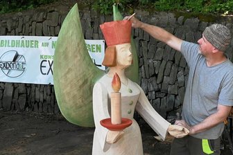 Holzbildhauersymposium in Aue: Letzter Feinschliff an Engel und Tasse - Friedhelm Schelter aus Königswalde frischt mit einem Pinsel die Farbe an seinem Engel auf. Die Figur soll später einmal den Raachermannelmarkt zieren. 