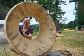 Holzkunst im Chemnitztal - Der Chemnitzer Künstler Frank Raßbach bearbeitet eine Holzskulptur.