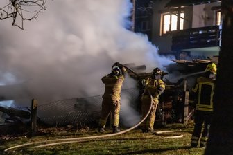 Holzstapel neben Mehrfamilienhaus fängt Feuer -