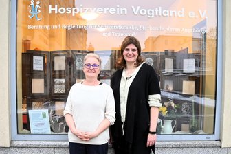 Hospizverein Vogtland zieht in Ladenlokal an der Bahnhofstraße: „Wir werden jetzt ganz anders wahrgenommen“ - Die Koordinatorinnen Johanna Schumann (li.) und Jeannine Lorenz vor dem Schaufenster.