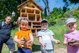 "Hoteleröffnung" pünktlich zum Weltbienentag - Kinder aus der Kita Hofgarten - hier v. r. Alina Müller, Valentin Rataj, Jonas Brecher - haben das von Ben Roscher (l.) gebaute und im Schlossgarten in Schwarzenberg aufgestellte Insektenhotel noch bestückt.