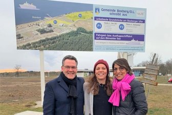 Hoteliersfamilie aus dem Erzgebirge legt Millionenprojekt auf Eis - Jens, Melanie und Carmen Ellinger (v. l.) 2021 vor der Bautafel am Bärwalder See.