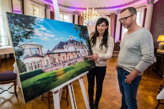 Hotelperle im Erzgebirge wird poliert: Warum das Restaurant „Artichoke“ im Hotel „Das Wolfsbrunn“ mehr Platz bekommt - „Das Wolfsbrunn“ in Hartenstein erweitert sein Restaurant „Artichoke“. Dafür wird die Terrasse zum Wintergarten. René Kowatsch, Vorstand der Meine Zeit AG und Hotelmitarbeiterin Claudia Curth an der Visualisierung.