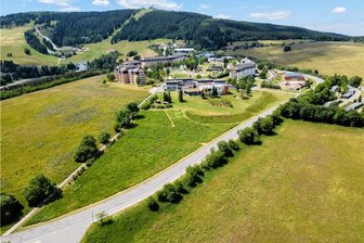 Hotels am Fichtelberg planen Bau von Solarfeldern - Blick zum Sparingberg und zum Elldus-Resort. Dahinter der Fichtelberg. Vorn genau zwischen dem Fußweg – auf dem früher die Alte Viehtrift weiter verlief – und der Dr.-Jäger-Straße ist der Wiesenhang zu sehen, auf dem die Solar-Freiflächenanlage für das Familien-Hotel entstehen soll.