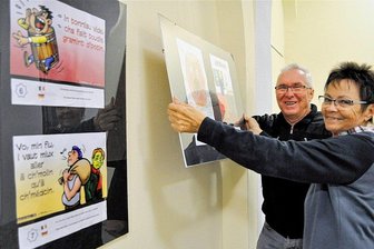 Humor trifft auf Kunst bei Ausstellung in Kirchberg - Roland Büttcher, Vorsitzender der Freundschaftsgesellschaft Kirchberg-Houdain, und seine Frau Silvia Gündel-Büttcher beim Hängen der Bilder im Rathaus. 