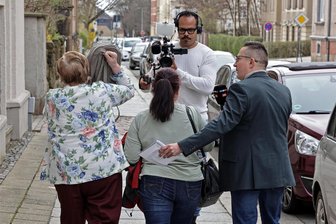 Hund kurz vorm Hitzetod im Auto: Medienrummel vor Tierquäler-Prozess in Hohenstein-Ernstthal - Am Dienstag vor dem Amtsgericht in Hohenstein-Ernstthal: Die Angeklagte (links) verbirgt ihr Gesicht vor der Kamera eines Fernsehteams. Zum Prozess kam es am Ende nicht, eine Strafe gibt es trotzdem.
