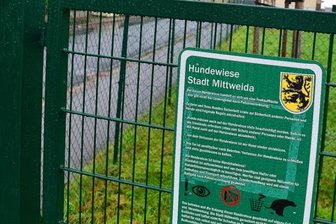 Hund totgebissen: Liegt die Schuld bei Loch im Zaun? - Im Zaun um die Hundewiese gibt es mehrere Schlupflöcher. Ein Schild am Eingang weist Halter auf ihre Aufsichtspflicht hin.