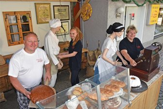 Hunderte Puppen belagern Dorfchemnitz - Die Bäckerfamilie René, Désireé und Manja Buschmann (v.l.) haben Inventar vor das Ladengeschädt gebaut.