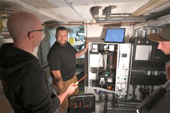 Hype um die Wärmepumpe ist vorbei: Was Mittelsachsens Heizungsbauer jetzt raten - Hausbesitzer Torsten Fischer (Mitte) hat sich von Heizungsbau-/Installateurmeister Christian Walcha (l.) und Kundendiensttechniker Robert Scholz ein Weishauptwärmepumpenhybridsystem in seinem Keller einbauen lassen.