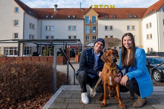 „Ich dachte, sie ist nicht mehr am Leben“ – Zwei junge Hoteliers starten in Frankenberg nach einem schweren Unfall neu - Anna Wolnik und Tobias Gawlowitz mit ihrem Hund Taco vor dem Akzent-Hotel in Frankenberg.