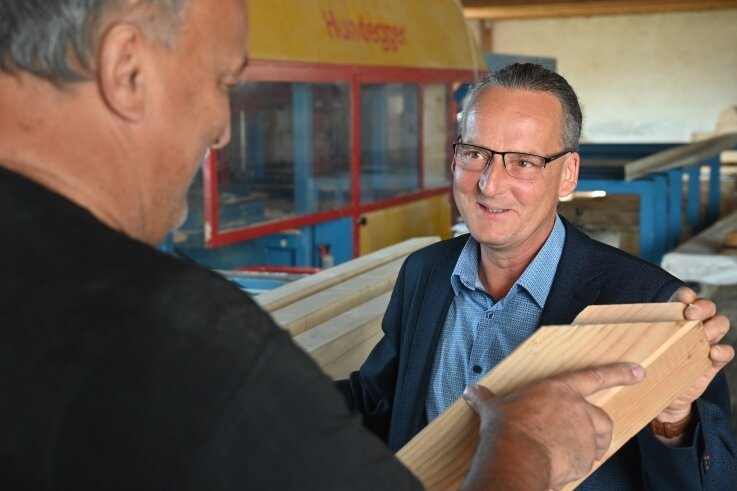 "Ich würde in eine kommunale Fotovoltaikanlage investieren" - Dirk Richter (rechts) auf Wahlkampftour in Taura im Gespräch über Handwerksarbeit mit dem Zimmerer Uwe Graichen. 