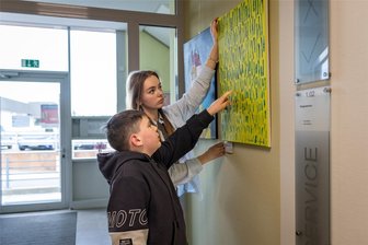 „Ich zähle die Tage, bis mein Vater aus dem Krieg zurückkommt“: Wie ukrainische Kinder den Krieg in Bildern verarbeiten - Platon Tsymbaliuk zeigt seiner Schwester auf seinem Bild, wie er die Erlebnisse in seiner Heimat verarbeitet.