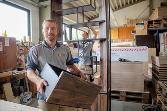 Ideen aus dem Erzgebirge: Holz in neuen Dimensionen und was das alles mit einer Reishülle zu tun hat - Einer der traditionsreichsten Werkstoffe des Erzgebirges, das Holz, gepaart mit moderner CNC-Bearbeitungstechnik, darauf setzt Thomas Körner in seinem Holzverarbeitungsunternehmen. In dem arbeiten Matthias Dost (links) und Andreas Stolle derzeit an einer Möbel-Sonderanfertigung für einen Kunden.