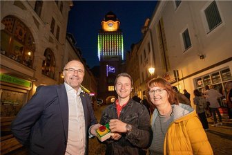 Im dritten Anlauf hat's geklappt: Plauener Rathausturm leuchtet zum Stadtgeburtstag - Den Startknopf für die Beleuchtung des Rathausturms drücke Plauens Oberbürgermeister Steffen Zenner (links). Mit von der Partie waren dabei Steffi Behncke aus dem Kulturreferat des Rathauses und Lucien Tunger, der für die Installation verantwortlich ist.