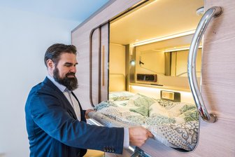 Im Erzgebirge in der Schlafkapsel übernachten: Pfiffige Idee für Ferienunterkunft geht an den Start - Mirko Sauerbaum, Geschäftsführer der Wohnungsbaugesellschaft Eibenstock, an einer der Schlafkapseln, die in den Ferienwohnungen in Oberwildenthal ab Ende Mai für Touristen bereitstehen sollen.