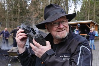 Im Erzgebirge liegt Kohlerauch in der Luft: Wo eine alte Tradition wieder auflebt - Hobbyköhler Heiko Schmidt lobt die Qualität der Holzkohle. Er hört es am Klang.