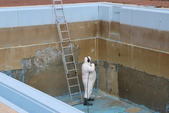 Im Pausaer Freibad trifft man in diesem Sommer nur Bauarbeiter - Im Schutzanzug wird hier im Schwimmbecken gearbeitet.