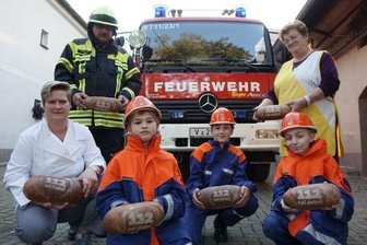 Im täglich Brot steckt eine Spende - Bäckerin Susanne Troll (rechts) und ihre Tochter Aline Zürnstein (links) backen bis Jahresende in jedes "urige" Brot eine "112 - sei dabei". 20 Cent pro verkauftem Brot gehen als Spende an die Jugendfeuerwehr Taltitz - das freut die jungen Feuerwehrleute Gustav, Willy und Marvin genauso wie Ortswehrleiter Marko Stüber.