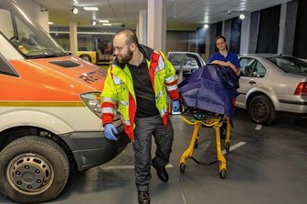 Im Vogtland öffnet Sachsens größte Notfall-Übungshalle - In der an ein Filmset erinnernden Simulationsanlage. Ramona Schumann, stellvertretende Ausbildungsleiterin, und ein Mitarbeiter spielen die Erstversorgung eines Unfallopfers durch - nach einem Unfall mit zwei Autos. Hinten ein Bus, in dem ebenfalls viele Szenarien bis hin zu einer Geburt durchgespielt werden können.