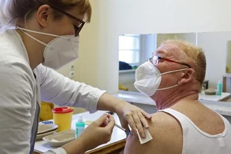 Impfärzte sitzen in Künstlergarderoben - Coronaschutzimpfung in der Künstlergarderobe: Dr. Grit Drechsler impft Jörg Kändler.