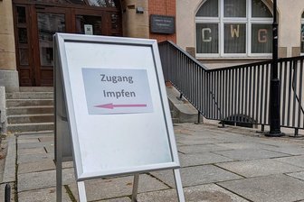 Impfaktion an Schulen: Wie es im Auer Gymnasium ablief - Dieser Aufsteller wies Schülern am Freitag den Weg Richtung Sporthalle. Ein mobiles Impfteam bot dort die Immunisierung gegen Corona an.