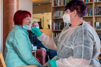 Impfquote des Heimpersonals ist unklar - Im Rochlitzer Altenpflegeheim müssen sich Besucher auf das Coronavirus testen lassen. Ab Montag gilt eine tägliche Testpflicht für das Pflegepersonal, welches bisher dreimal pro Woche getestet wurde. Im Bild: Mitarbeiterin Nicole Rost testet die Besucher Margitta Große und Camillo Zimmer.