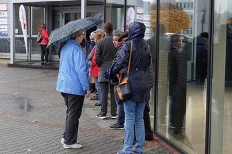 Impfwillige warten im Regen: In Zwickau wollen zu viele den Booster - Warteschlage vorm Eingang zur Impfstelle im Autohaus Lueg an der Schubertstraße.