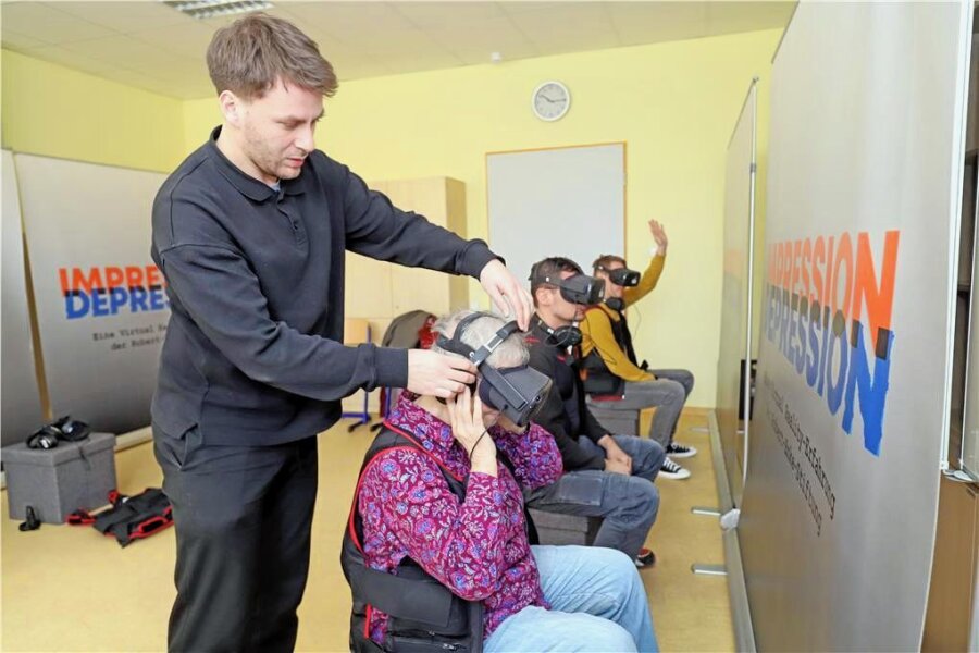 "Impression Depression": Virtuelle Erfahrungen mit einer schwierigen Krankheit in Freiberg - Gianluca Maione hilft den Besuchern beim Anlegen der VR-Brillen. 