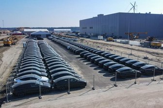 Elektrofahrzeuge vom Typ Tesla Model Y stehen aufgereiht vor der Tesla Gigafactory in Grünheide.