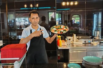 In Bienenmühle gibt es nun Pizza, Pasta und Baguette - Der Gastronom Saeed Shah zeigt stolz seine Pizza Tonno.