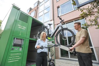 In Chemnitz kann man sich jetzt auch Elektro-Fahrräder ausleihen - Jette Rüdiger vom Hotel c/o56 und Patrick Rabe von der RWC Factory holen ein E-Bike aus dem Verleihcontainer.