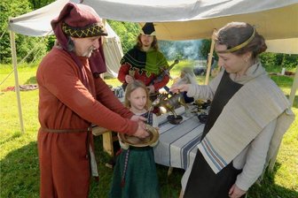 In der Freizeit zurück ins Mittelalter: Warum Heinrich von Valkinstein und seine Getreuen in Ellefeld ihr Lager aufschlagen - Handwaschung zur Begrüßung eines Gastes im Lager: Irida und Sarah Scharf reichen Tino Hartig Wasser; im Hintergrund Alexander Stoll als Heinrich von Valkinstein.