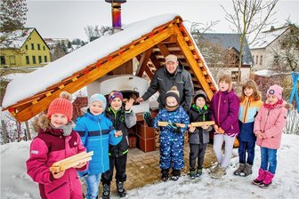 In Eppendorf gibt es eine neue Bäckerei - und die steht in der Kita - Kinder der Hortgruppe der ersten und zweiten Klasse mit Ofenbaumeister Bert Eppendorfer am neuen Backofen der Kita "Pfiffikus" in Eppendorf.
