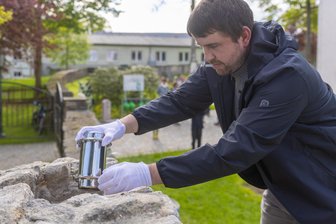 In Kriegerdenkmal im Erzgebirge liegt jetzt eine Zeitkapsel - Vorsichtig versenkte Grumbachs Ortsvorsteher Michael Winkler eine Zeitkapsel im Denkmal.