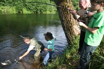 In Marbach lassen Kinder die Fische zappeln - Anglerglück: Ingolf Lindner und Sohn Johannes helfen mit dem Kescher nach. Oliver Fröhlich und Hans Hillger halten die Angel fest. Foto: Claudia Dohle