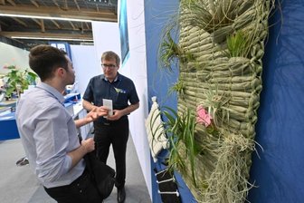 Institut entwickelt Begrünung für ein besseres Stadtklima - Besucher am Stand vom Sächsischen Textilforschungsinstitut bei der Messe Techtextil in Frankfurt am Main. Von besonderem Interesse dabei für die Gäste: diese zur Schau gestellte Wandbegrünung.