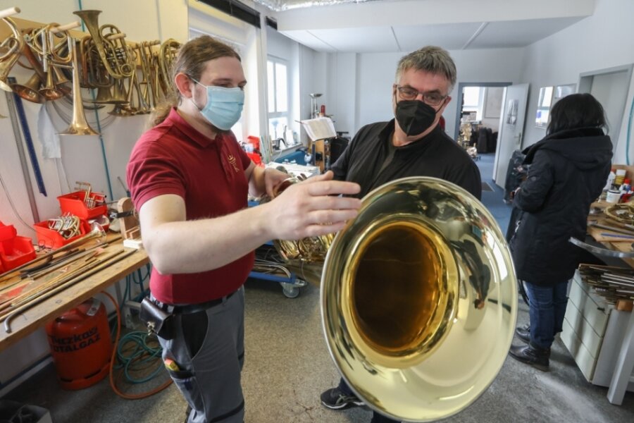 Instrumentenbau in Chemnitz: Kroning Meisterinstrumente gibt Einblick in seine Werkstatt - Bernhard Kroning (links) zeigt einem Besucher der Kunsthandwerkstage in seiner Werkstatt eine Tuba. Er selbst spielt dieses Instrument. 