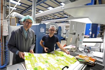 Investition sorgt für gutes Betriebsklima - Geschäftsführer Ulli Mugler (links) und Offsetdrucker Daniel Dietrich (li.) prüfen die Druckqualität der Bögen für die künftigen Zitronentee-Verpackungen. Dank der neuen Klimaanlage herrscht an der Maschine immer frische Luft.