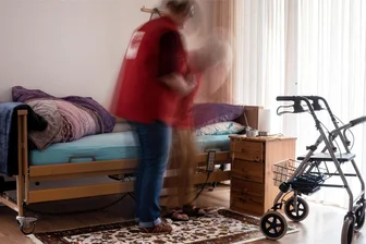 Irritierende Corona-Briefe im Vogtlandkreis: Post aus dem Gesundheitsamt reißt Wunden wieder auf - Eine Pflegerin hilft einer Seniorin beim Aufstehen aus ihrem Bett. Tausende Helferinnen und Helfer leisten tagtäglich wertvolle Arbeit. Das Vorgehen gegen die Ungeimpften im Gesundheits- und Pflegebereich ist bis heute umstritten. Letztlich beließen es die Behörden im Vogtlandkreis bei Drohgebärden.
