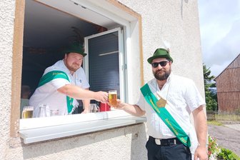 Ist der Vogel einmal abgeschossen: Der letzte Tag eines Königs im Erzgebirge - Der Schützenkönig 2023/24, Sepp Meyer (l.), zapft Daniel Wohlgemuth ein Bier. Die Tradition in Niederlauterstein besagt, dass der Titelinhaber die Schützengilde vor dem Fest verköstigen muss.