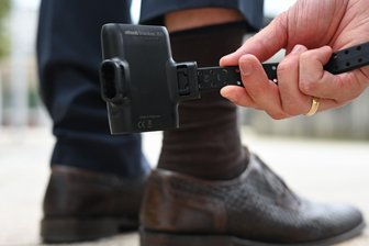 Ist die elektronische Fußfessel die Lösung gegen häusliche Gewalt? - Einem Mann wird eine elektronische Fußfessel angelegt.