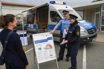 Ist Lichtenau ein unsicheres Pflaster? - Polizeihauptmeisterin Kathy Seyferth (rechts) und Hauptkommissar Uwe Nerger von der Polizeilichen Beratungsstelle der Polizeidirektion Chemnitz beraten eine Lichtenauerin über Einbruchsschutz an ihrem Wohnhaus. Das Präventionsmobil hielt am Montagvormittag im Olipark Oberlichtenau.