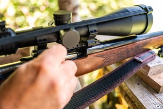 Jäger, Tod und Natur: Müssen wir den Umgang mit Wildtieren neu verhandeln? - Ein Jäger lädt auf seinem Hochsitz eine Jagdpatrone in sein Gewehr.