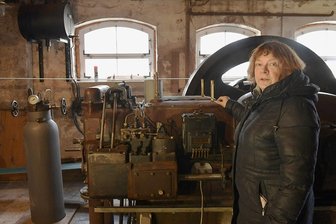 Jahrhundertflut: Als die Brettmühle Mulda unter Wasser stand - Sägewerkvereinsmitglied Petra Schumann im Februar diesen Jahres vor dem Deutz-Dieselmotor, der am 13. August 2002 im Wasser stand. Heute treibt er die gesamte Sägetechnik in der Brettmühle Mulda an.
