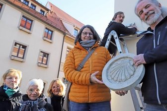 Jakobsmuschel aus Sandstein weist den Weg - Steinmetz- und Steinbildhauermeister Tobias Neubert (r.) und Initiatorin Sabine Lohmann mit der neuen Jakobsweg-Markierung an der Mönchstraße in Freiberg. Gemeinsam mit ihnen freuen sich drei der zehn Sponsorinnen und Geselle Sebastian Klar.